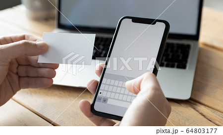 Close up businessman holding blank business card and phone Close up businessman holding blank business card and phone 64803177