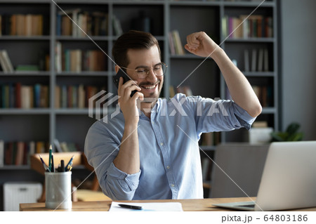 Smiling satisfied businessman making phone call, hearing good news Smiling satisfied businessman making phone call, hearing good news 64803186