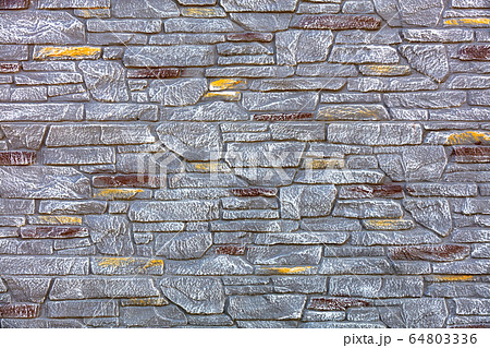 Aged stone fence made of natural stones 64803336