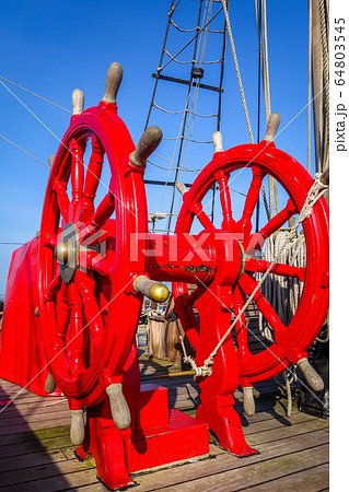 Red wheel helm on antique ship Red wheel helm on antique ship 64803545