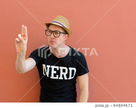 Portrait of young nerd tourist man touching something 64804673