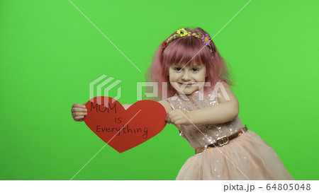 Child girl princess holds red paper heart with text about mother. Mother's day 64805048