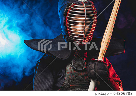 confident kendo fighter in armor practicing with bamboo sword 64806788