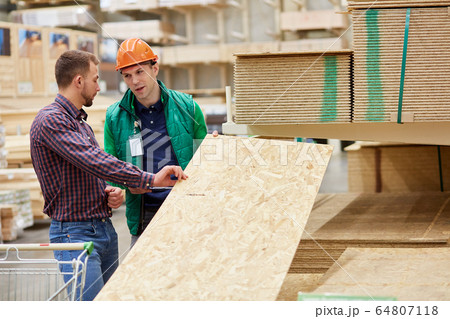 warehouse worker show the best variant of wooden board in their market 64807118