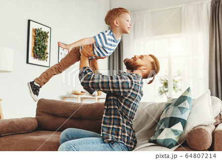 Happy man having fun with son at home 64807214