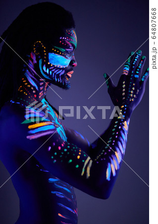 muscular young man in bright blacklight bodyart glowing in darkness muscular young man in bright blacklight bodyart glowing in darkness 64807668