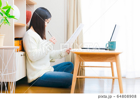 自宅で書類をチェックする女性 コピースペース 自宅で書類をチェックする女性 コピースペース 64808908