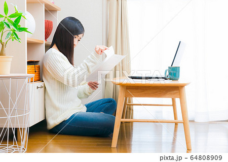 自宅で書類をチェックする女性　コピースペース 64808909