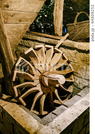 The wheel of a water mill. The old wooden wheel of the water mill is used as an element of decor on the wall. 64809252