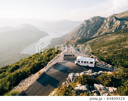 Caravan at the top of Mount Lovchen in Montenegro. A house on wheels near a mountain cliff. Trailer with panoramic views of Kotor Bay. Caravan at the top of Mount Lovchen in Montenegro. A house on wheels near a mountain cliff. Trailer with panoramic views of Kotor Bay. 64809329