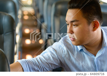 Young overweight Asian tourist man riding inside the train 64809716