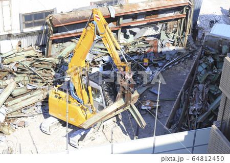 解体用つかみ機で作業する解体現場 64812450