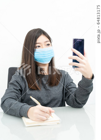 Woman long hair wearing protective mask holding 64813175