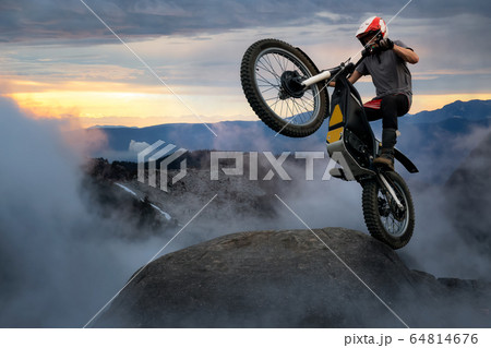 Extreme Adventure Man Motorcycle trials on top of a rock. 64814676