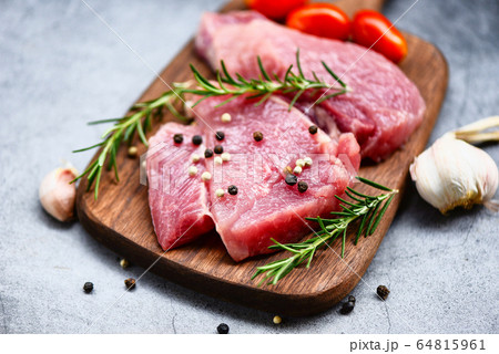 Raw pork meat on wooden cutting board at kitchen Raw pork meat on wooden cutting board at kitchen 64815961