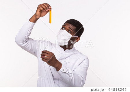 Glass tube with yellow fluid in doctor hand during medical test. Vaccine development, experiments and science concept. 64818242