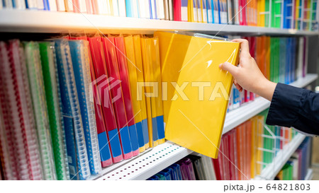 Male hand choosing file folder in stationery shop Male hand choosing file folder in stationery shop 64821803