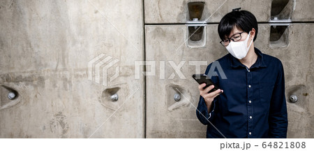 Asian man wearing mask using phone in subway Asian man wearing mask using phone in subway 64821808