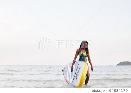 Surfer walking out of sea Surfer walking out of sea 64824179