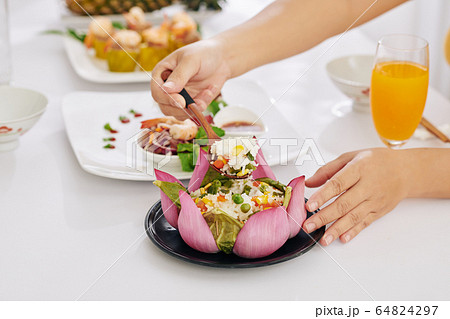 Woman taking spoon of rice from dish Woman taking spoon of rice from dish 64824297