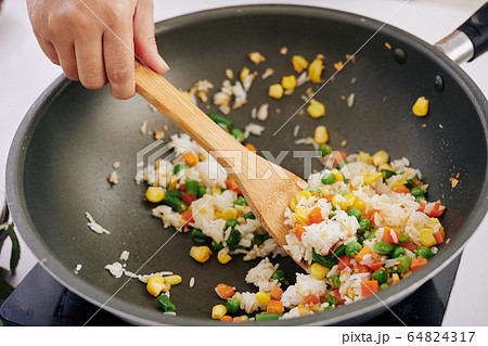 Woman frying rice with vegetables Woman frying rice with vegetables 64824317