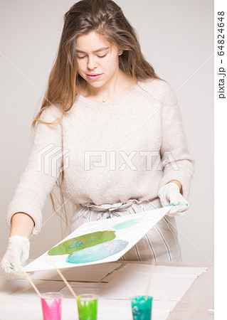 The girl creates a picture with abstraction in bright colors. 64824648