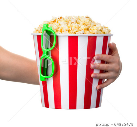 Woman hand holding striped bucket with popcorn and Woman hand holding striped bucket with popcorn and 64825479