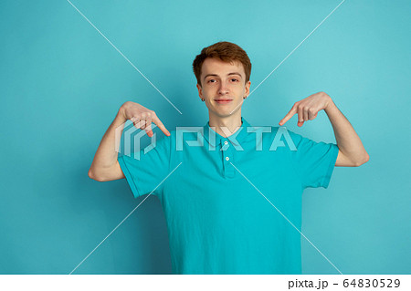Caucasian young man's monochrome portrait on blue studio background, emotinal and beautiful 64830529