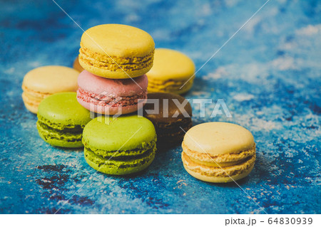 Variety of colorful macarons over a blue 64830939