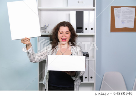 Concept of dismissal from work. Happy woman with carton box with her stationery stuff, girl was fired from her job. Concept of dismissal from work. Happy woman with carton box with her stationery stuff, girl was fired from her job. 64830946