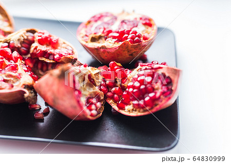 Fresh ripe pomegranate on table close up. Fruit , vitamins and food concept. Fresh ripe pomegranate on table close up. Fruit , vitamins and food concept. 64830999