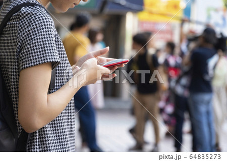 スマホを操作する若い女性の手元 スマホを操作する若い女性の手元 64835273