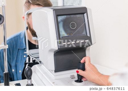 Medicine, health, ophthalmology concept - patient checks her vision by an ophthalmologist. Medicine, health, ophthalmology concept - patient checks her vision by an ophthalmologist. 64837611