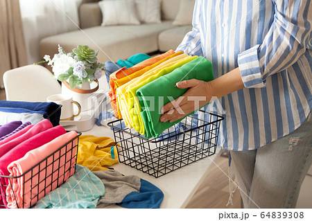 Woman in casual clothes lays clothes in metal mesh 64839308