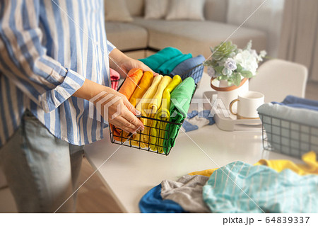 Woman in casual clothes lays clothes in metal mesh 64839337