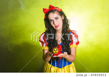 Woman dressed as fairytale character holds Radioactive atomic nuclear ionizing radiation danger warning symbol on apple. Nuclear and radiation measurement concept. 64839933