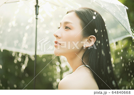 きれい 女性 雨 降る 傘 濡れる 人物 素材の写真素材