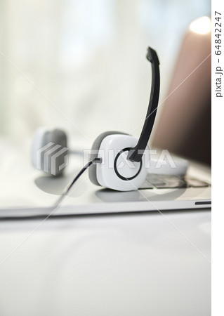 Close-up of white headphones with microphone on blurred background. Close-up of white headphones with microphone on blurred background. 64842247