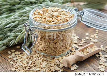 Jar of oat flakes and green oat ears. Jar of oat flakes and green oat ears. 64842787