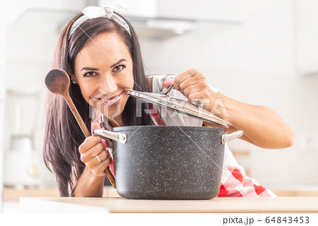 Detail of a young cook opening a pot lid and 64843453