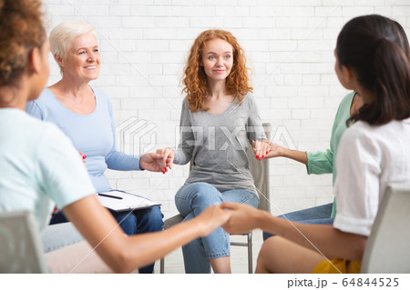 Multicultural Women Holding Hands Sitting In Circle During Therapy Indoors 64844525