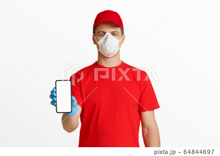 Phone with empty space in hand of courier in red uniform 64844697