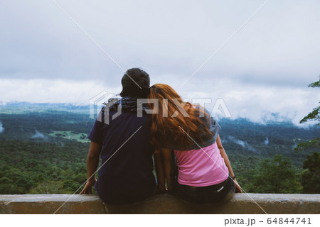 Couple sitting in front of a mountain looking at the horizon in the holiday. Travel relax. 64844741