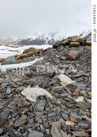 Garbage scattered over snowy mountain. Let's save the planet and recycle the excess garbage. Pollution Concept 64845653