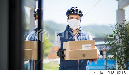 Courier with face mask delivering parcel, corona virus and quarantine concept. 64846218