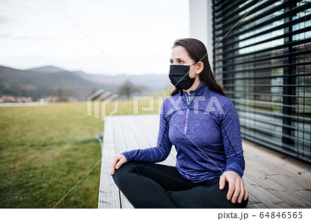 Woman with face masks outdoors at home, Corona virus and quarantine concept. 64846565