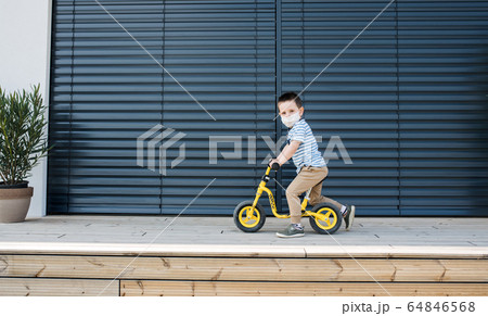 Small boy with bicycle outdoors at home. Corona virus and quarantine concept. 64846568
