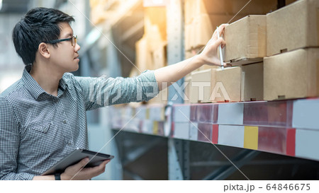 Asian man doing stocktaking by using tablet in 64846675