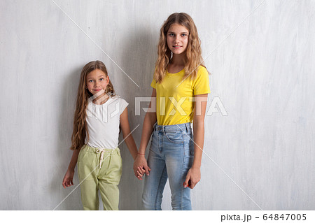 Two beautiful girls holding hands with a friend Two beautiful girls holding hands with a friend 64847005