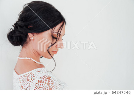 Portrait of a beautiful fashionable brunette woman in a dress with flowers 64847346